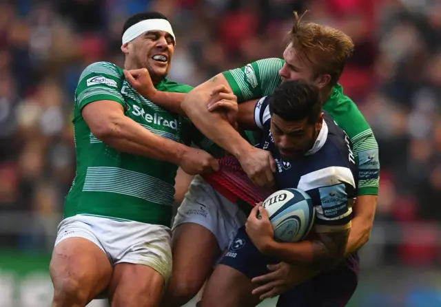 Charles Piutau of Bristol Bears is tackled by Chris Harris and Josh Matavesi