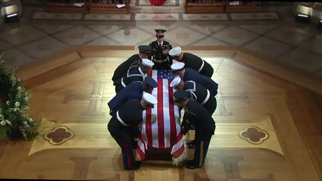 Body bearers take up casket