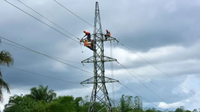 Liberian electricity workers fix high voltage cables on the outskirts of Monrovia on October 12, 201