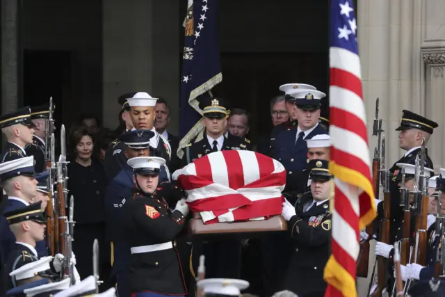 The flag-draped casket of George HW Bush departs the National Cathedral following his state funeral