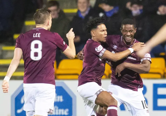 Hearts' Arnaud Djoum (right) celebrates with teammates Olly Lee and Demetri Mitchell