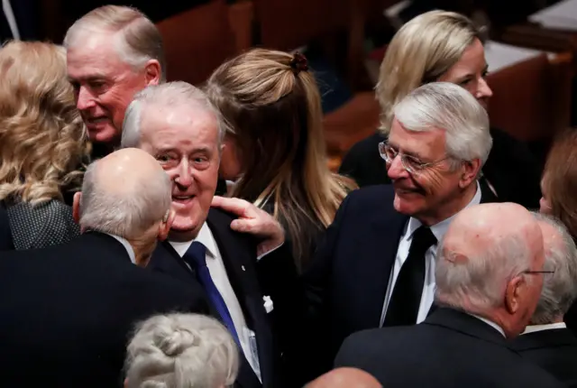 Former Canadian Prime Minister Brian Mulroney is greeted by former British Prime Minister John Major