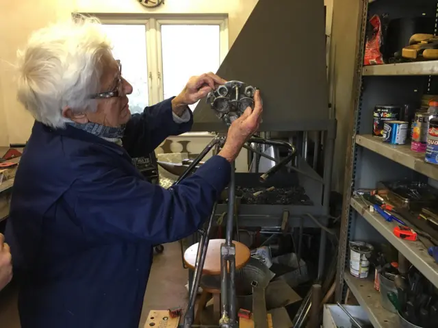 94-year-old lady working on steel skiing man sculpture