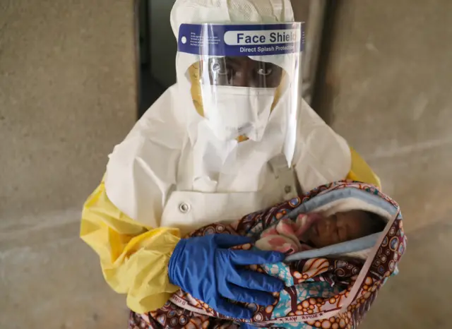 A health care worker carries a baby suspected of being infected with Ebola virus in a hospital in Oicha, North Kivu Province of Democratic Republic of Congo, December 6, 2018.