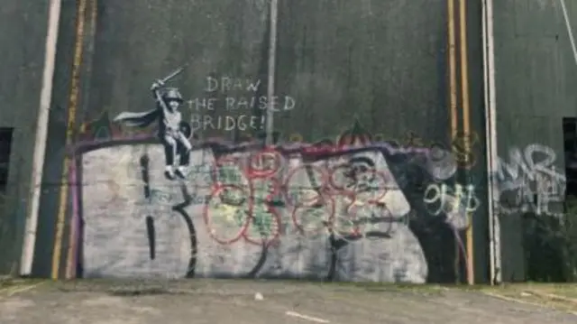 Banksy on raised bridge