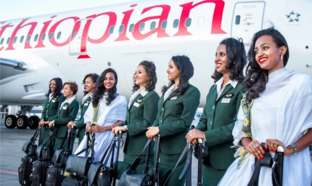 Ethiopian Airlines staff pose for the cameras next to one of the carrier's aircraft