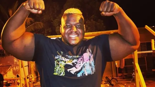 Cheick Ahmed al-Hassan Sanou flexes his biceps and smiles for the cameria