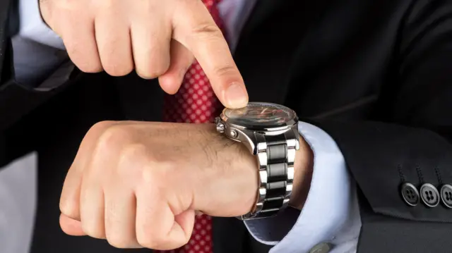 A man pointing at a watch