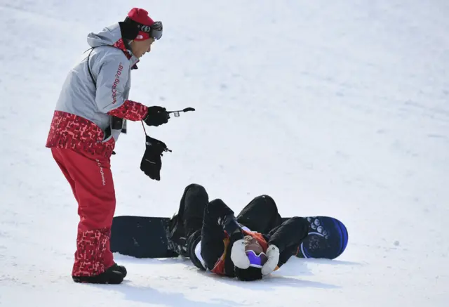 An official helps Mads Hedberg after he falls in the first run