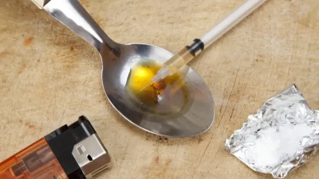 Heroin concept shot with a spoon, lighter, and a needle