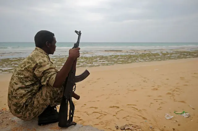 A member of the Somali security forces stands guard on the beach on the coast in 2016.