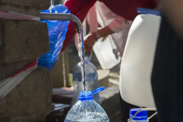 People queue up to collect drinking water from taps that are fed by a spring in Newlands on May 15, 2017, in Cape Town.