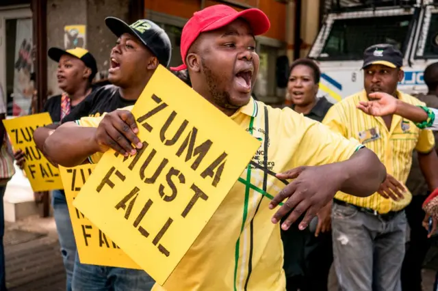 Supporters of the African National Congress Deputy President Cyril Ramaphosa hold placards and chant slogans outside the ANC party headquarter in Johannesburg, on February 5, 2018