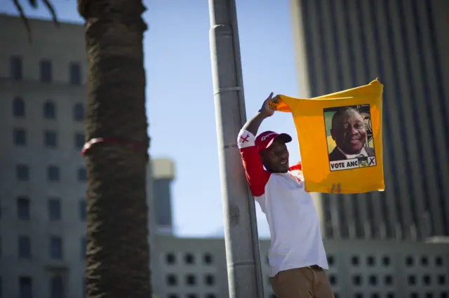 A supporter of South Africa's ruling African National Congress (ANC) holds up a shirt featuring newly-elected ANC president and South African Deputy President, Cyril Ramaphosa, during a rally on February 11, 2018 in Cape Town