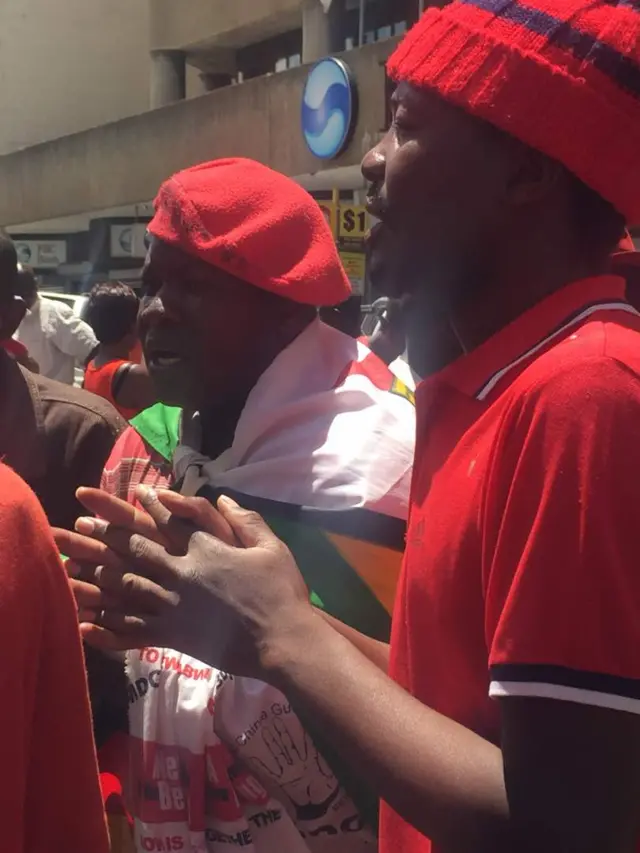 MDC supporters stand together crying and mourning the death of their leader Morgan Tsvangirai