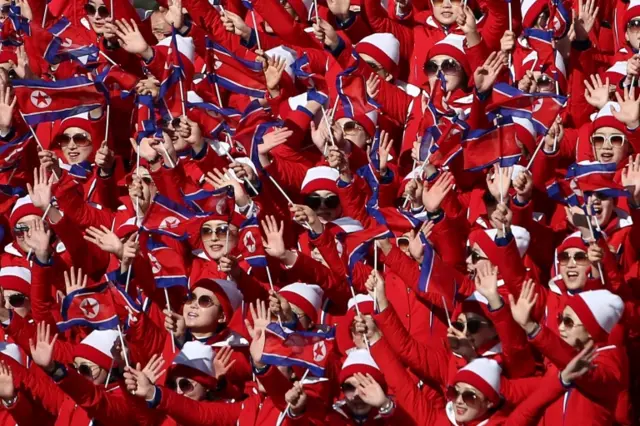 North Korea fans wave flags at the finish during the women's giant slalom