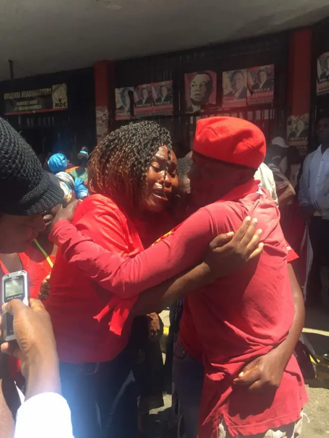 MDC supporters stand together crying and mourning the death of their leader Morgan Tsvangirai