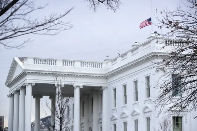 The US flag is seen flying at half mast atop the White House on 15 February