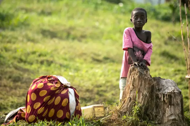 A Congolese refugee girl waits to cross into Uganda