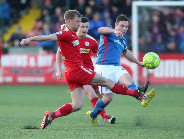 Cliftonville's Liam Bagnall in a race for the ball with Blues captain Jamie Mulgrew
