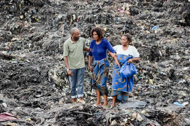 People react as they watch rescuers searching for bodies of victims buried under collapsed garbage piles in Maputo, Mozambique, 19 February 2018.