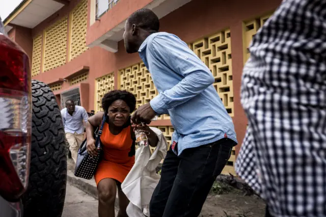 Catholic faithfuls run for cover after police fired tear gas to disperse a demonstration to call for the President of the Democratic Republic of the Congo to step down, on December 31, 2017 in Kinshasa