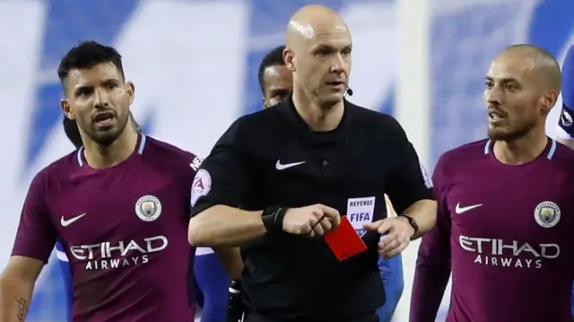 Referee Anthony Taylor reaches for the red card