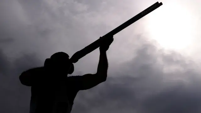 Person taking part in clay pigeon shooting