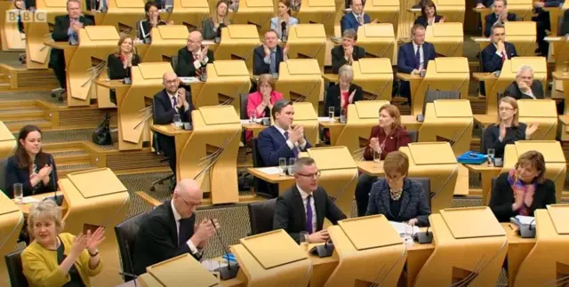 Applause from the SNP benches as the budget passes