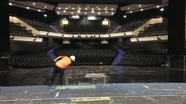 A builder paints the stage in the hold Haymarket Theatre