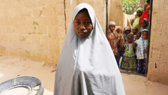 Hassana Mohammed, 13, who scaled a fence to escape an alleged Boko Haram attack on her Government Girls Science and Technical College, stands outside her home in Dapchi, Nigeria, on February 22, 2018.