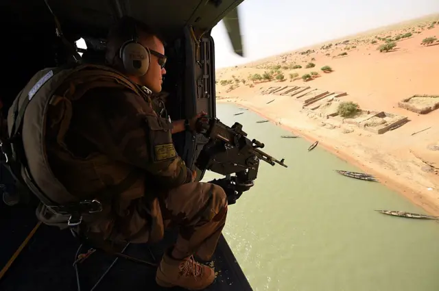 A French soldier of the operation Barkhane, an anti-terrorist mission in Sahel, patrols during a tactical flight on March 12, 2016 over Mali