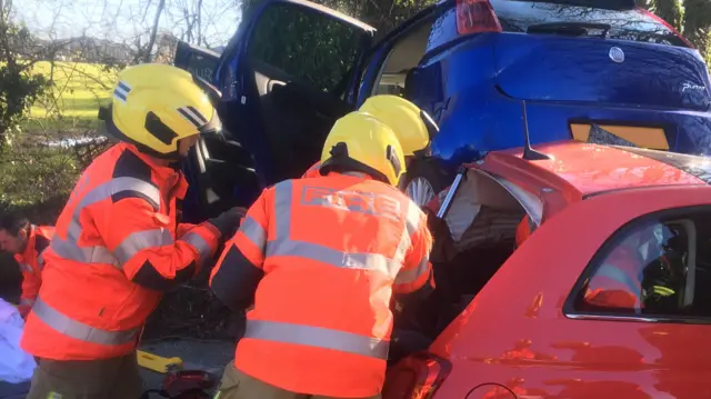 Fire crews work to get someone out of a car