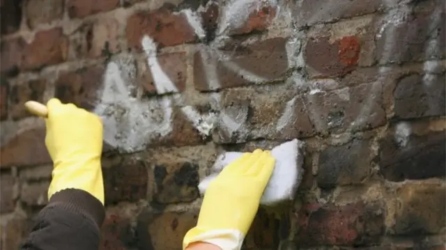 Person cleaning graffiti