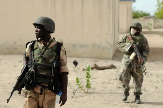 Nigerian soldiers patrol in the north of Borno state close to a Islamist extremist group Boko Haram former camp on June 5, 2013 near Maiduguri.