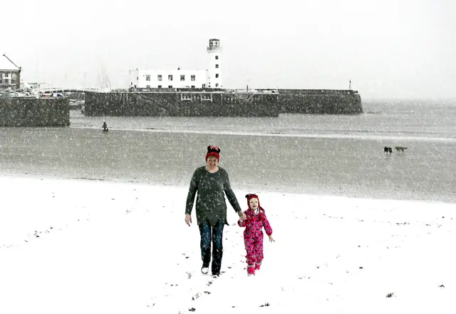 A woman and child enjoy the snow at Scarborough North Bay beach