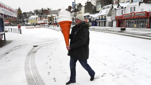 Brett Canham prepares his catering stall on Scarborough seafront, as heavy snowfall is affecting roads across the UK on Tuesday morning after several centimetres fell in some parts over the night.