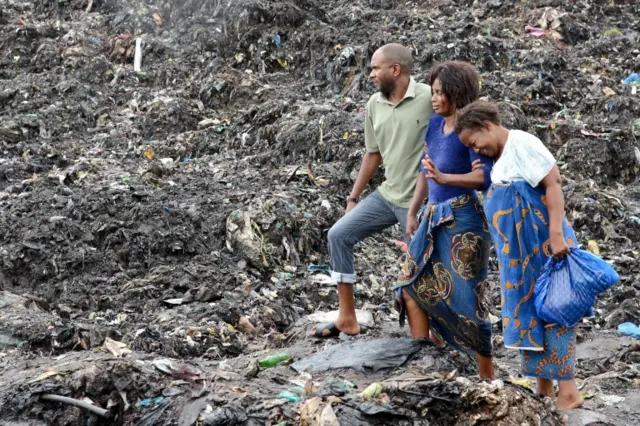 2 People react as they watch rescuers searching for bodies of victims buried under collapsed garbage piles in Maputo, Mozambique, 19 February 2018