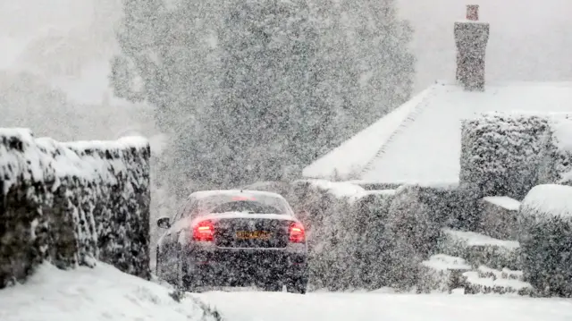 A car travelling through a snow blizzard in Ashford, Kent, on Tuesday morning.