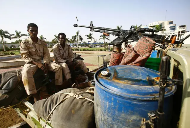 Sudanese security forces sit on the back of a heavily armed vehicle outside the defence ministry in the capital Khartoum in 2016.