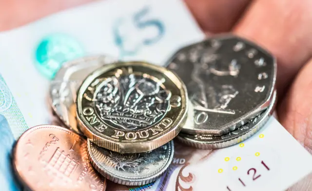 A man holding sterling cash