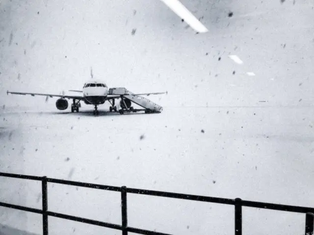 Heavy snow falls on the tarmac of the Glasgow Airport in Glasgow