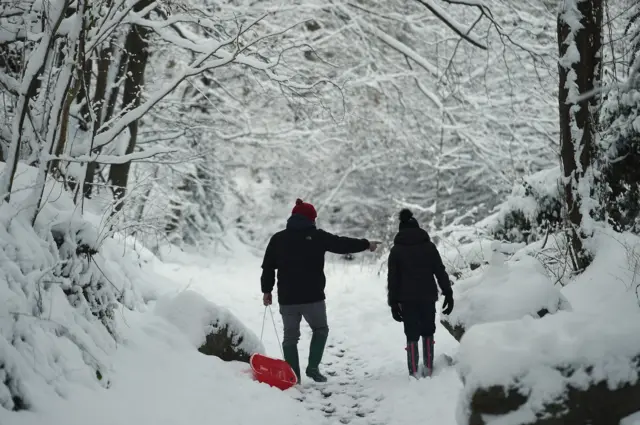 A family take a walk in the snow in Wales