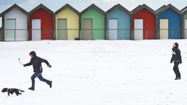 People walking in snow on beach