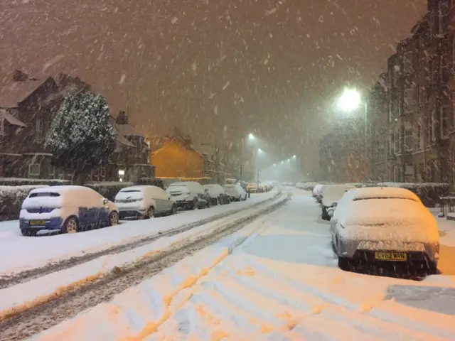 Snow falls in a street in Shawlands, Glasgow,