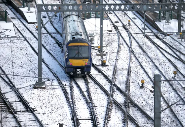 A ScotRail train leaves Edinburgh"s Waverley Station. Many train services have been cancelled or delayed as heavy snow caused more misery for travellers