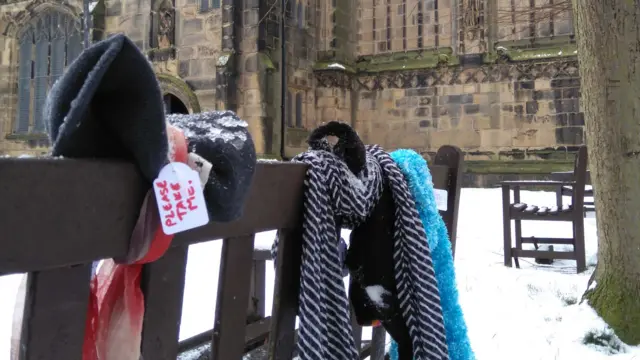 Hats and scarves tied to a bench