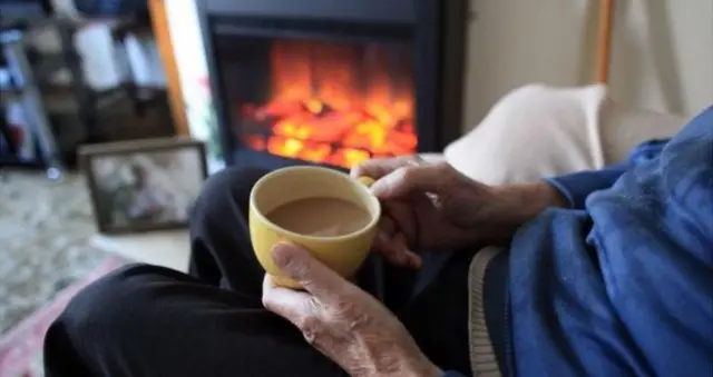 Man sits by the fireplace