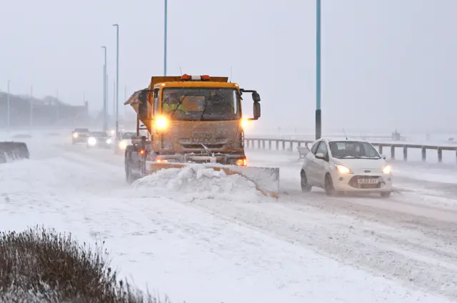 Snow plough shovels show from a road in Whitley Bay