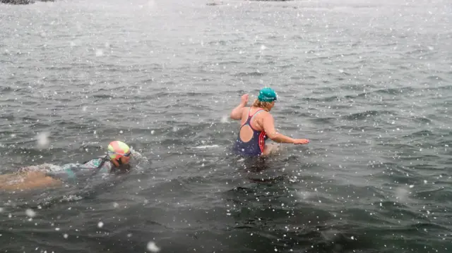 Members of the Battery Belles and Buoys, a wild sea swimming group that swim every day in the sea at from the Battery Rocks in Penzance take a dip in the sea as heavy snow arrives on February 28, 2018 in Cornwall, England. Freezing weather conditions dubbed the "Beast from the East" has brought snow and sub-zero temperatures to many parts of the UK.